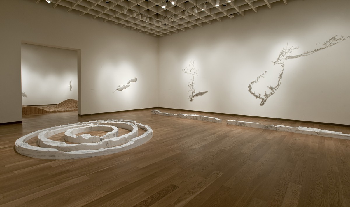 Installation view of the exhibition: Maya Lin: A History of Water, Orlando Museum of Art January 31–May 10, 2015. Foreground in marble: Around the World, 2013-2014; 74° West Meridian, 2013; and 106° East Meridian, 2013. On the wall (left to right): Silver Niagara, 2012-2013; Pin River – Hudson, 2013; and Pin River – Sandy, 2013, © Maya Lin Studio, courtesy Pace Gallery.