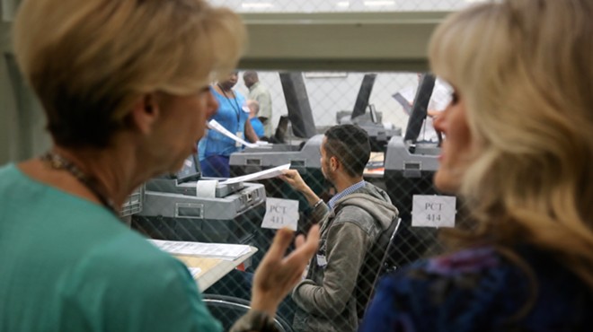 Onlookers watch rows of poll staffers tackle the first wave of recount ballots inside an Orange County Supervisor of Elections warehouse on Nov. 12 2018.