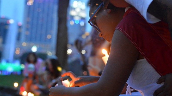 A woman lights a candle at a small vigil for victims of the mass shooting at Pulse nightclub in Orlando.