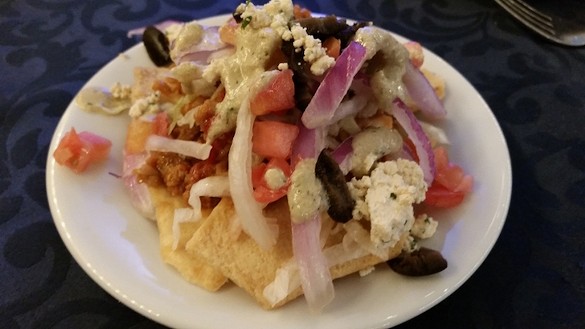 Loaded Greek "nachos": pita chips, meatless sausage crumbles, vegan tzatziki (Greece)
