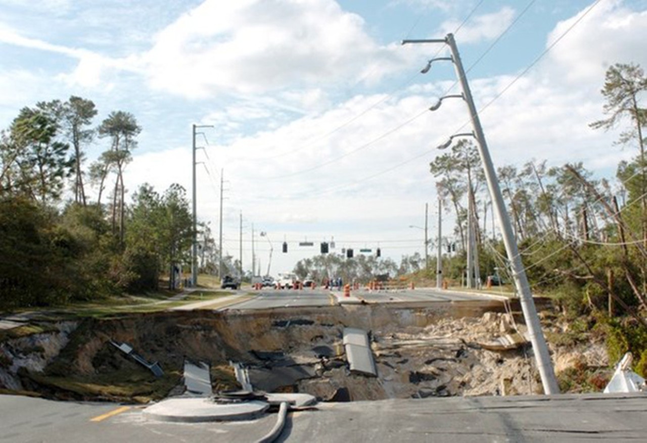 Sinkhole devours 160-foot stretch of Deltona road
December 20, 2004
Good luck getting anywhere in this stretch of Deltona. A huge sinkhole destroyed all four lanes of this road, and experts estimate this it'll take 100,000 truckloads of sand to fill the crater left behind by this natural disaster.
Photo via iamhrishabhkashyap.blogspot.com