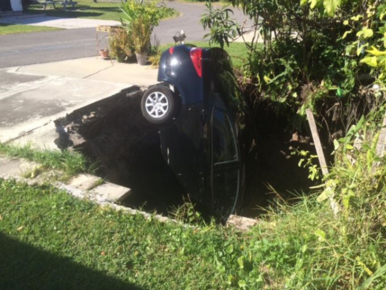 Sinkhole swallows car in Holiday, Fla.
November 11, 2014
A woman's Hyundai Accent took a trip down Sinkhole Lane when a 10-footer opened up next to her trailer home. She saw the tires sinking into the pavement slightly, then proceeded to grab as much as she could before hauling ass from the scene. She was evacuated from her trailer and the car was retrieved from the hole five days later.
Photo via wtsp.com