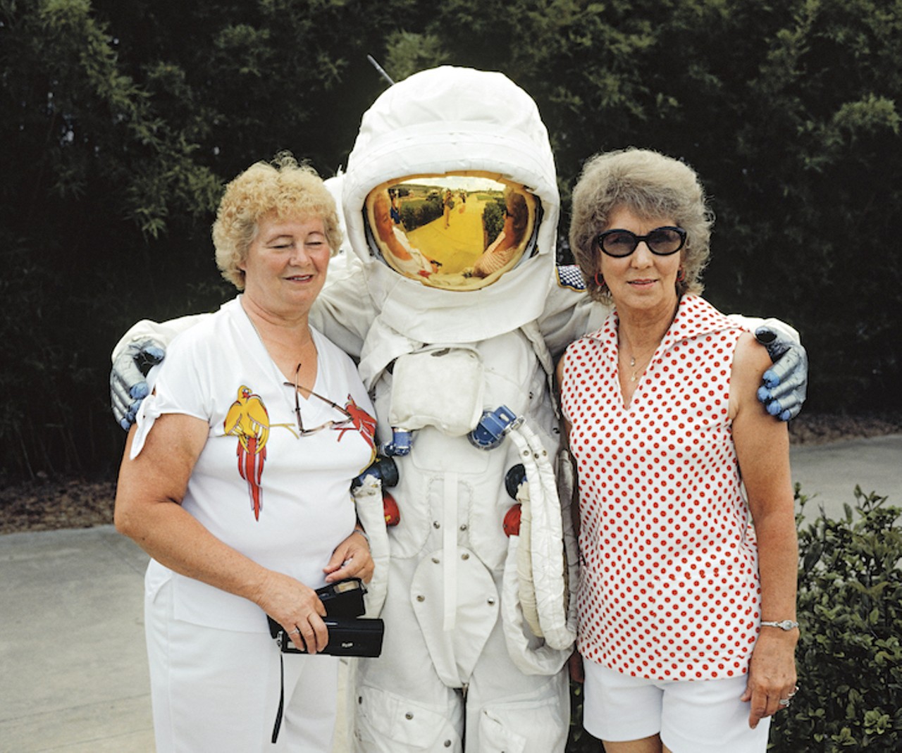 Tourists to the Kennedy Space Center in Orlando, Florida posing with a pretend astronaut in an Apollo spacesuit. Administered by NASA, KSC is a major tourist attraction for tourists to the Orlando area. Two million people visited in 1981, making KSC the fourth most popular destination for Florida tourism. 1981.