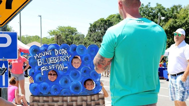 Festival goers at the 2018 Mount Dora Blueberry Festival take pictures in the blueberry sign.