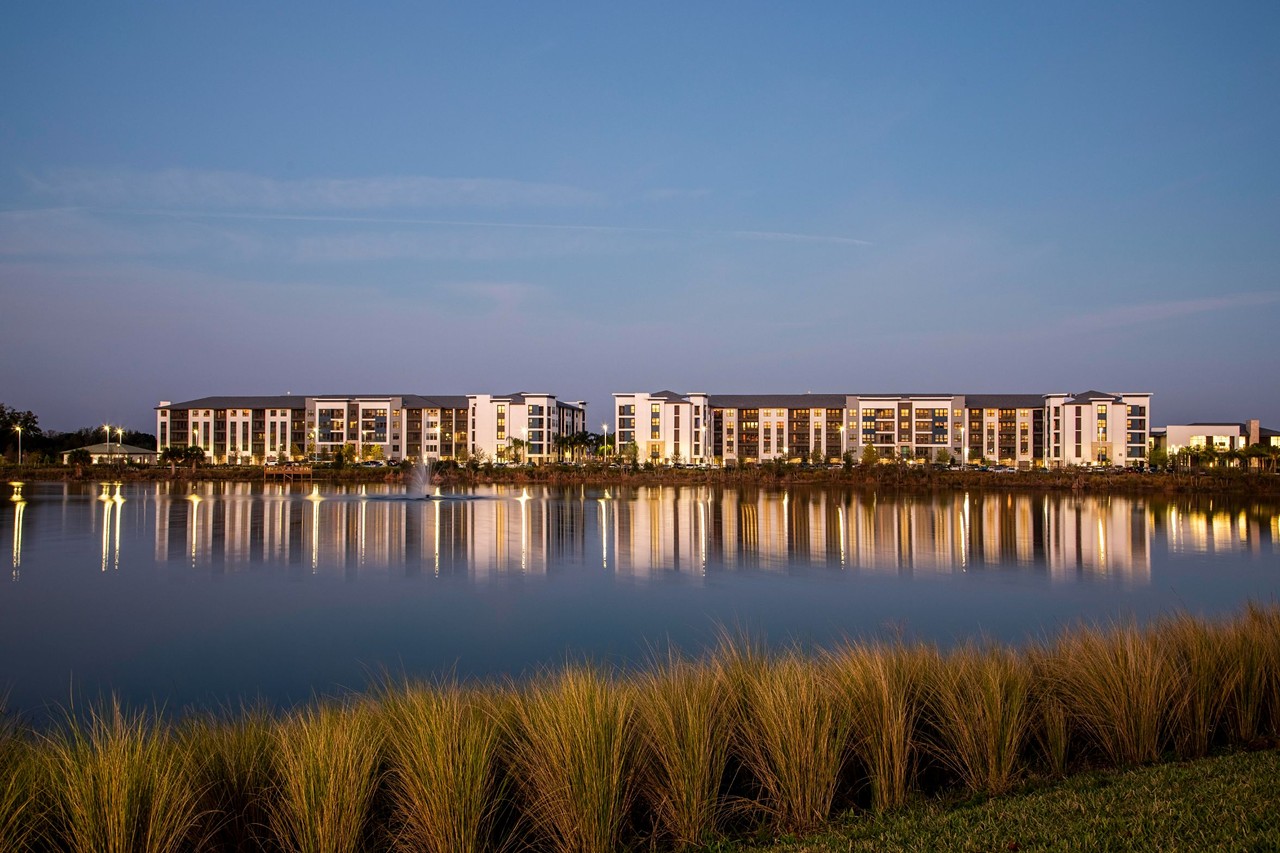 Exterior view of Jefferson Sand Lake apartment community from the shores of Mirror Lake