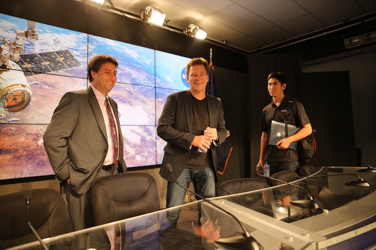 Joel Montalbano and Hans Koenigsmann give brief answers to press after the post-launch press conference at 2am, Monday morning. An aide from SpaceX (pictured right) appeared immediately after the conference to usher Koenigsmann out. Following press conferences like this one, SpaceX executives don&#146;t tend to hang around for questions like NASA representatives do. In fact, Hans and his aide actually ran through the mob of reporters and out the door at Saturday&#146;s pre&shy;launch news briefing.