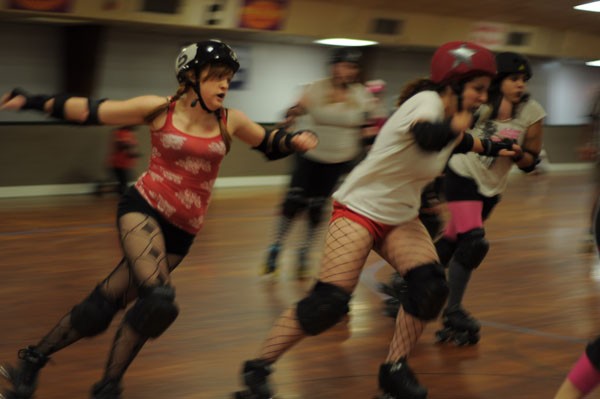Playing nice: The Bellevue Bombshell jammer known as ‘Ellen Rage’ passes by Serial Thriller player ‘Knock’em Over Clover’ during a practice bout in October. - J. Hunter Sizemore
