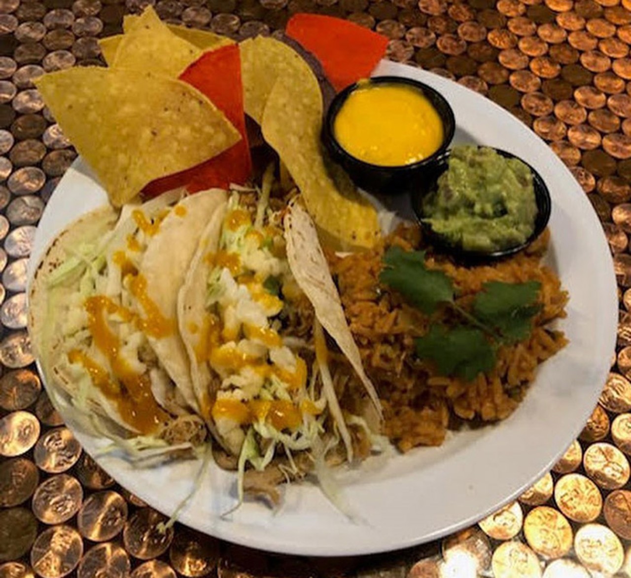 The Copper Rocket  
106 Lake Ave., Maitland, FL 32751, 407-853-5036
Two Chicken Tinga Tacos- Mouthwatering chicken tinga tacos served on flour tortillas with slivered green cabbage and cotija cheese, Mexicali rice, and tri colored tortilla chips served with guacamole and nacho cheese dipping sauce.
Photo via The Copper Rocket