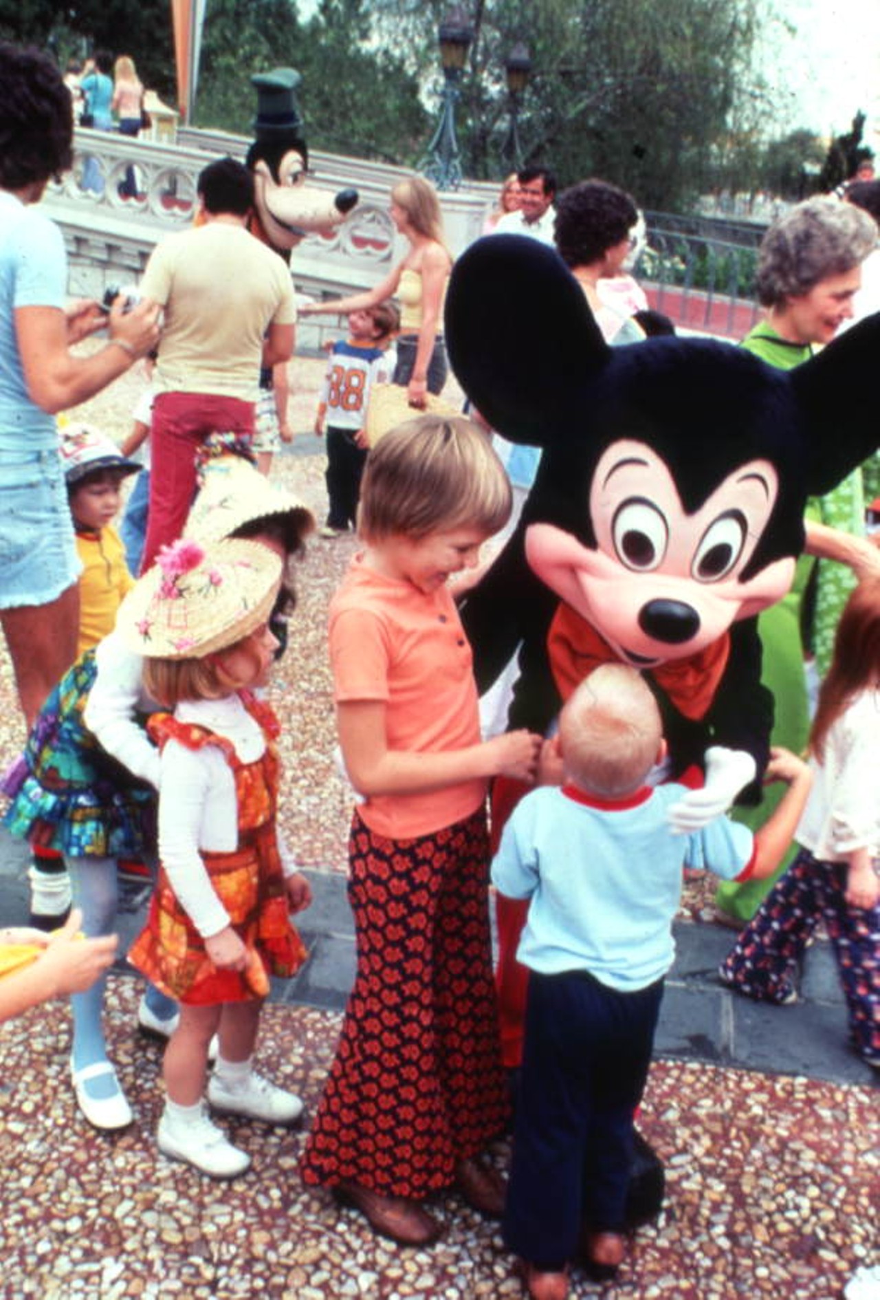Children (wearing groovy bellbottoms) meeting Mickey Mouse at the Magic Kingdom amusement park in Orlando, Florida, 1977