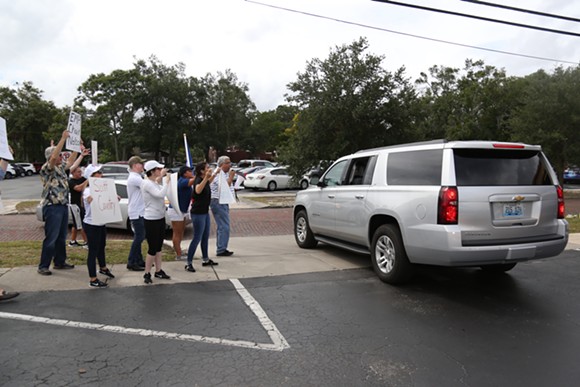 Demonstrators protest Ricardo Rosselló as his motorcade leaves for an Andrew Gillum event in Kissimmee on Monday. - Photo by Joey Roulette