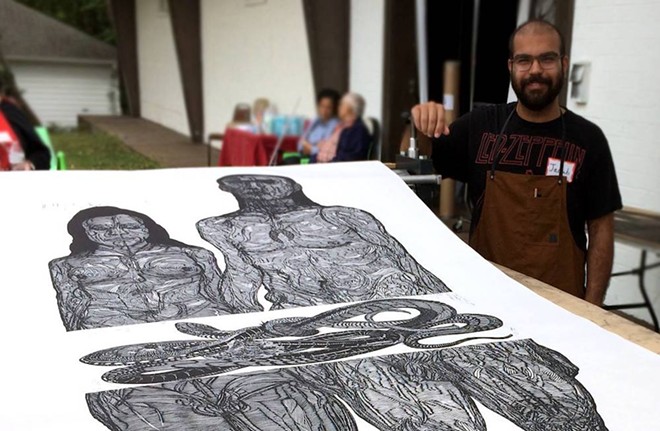 Jacoub Reyes alongside his monumental woodcut print at Atlanta Printmakers Studio - PHOTO BY BIG INK / FACEBOOK