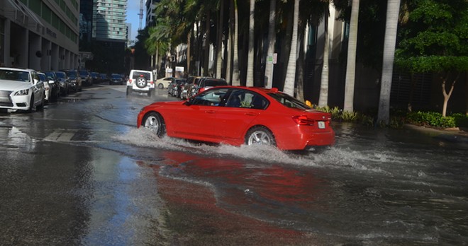 A car drives through flooded streets in Miami - PHOTO VIA B137/WIKIMEDIA COMMONS