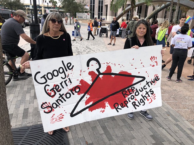 Vicki Impoco and Nelly Cardinel hold an "RIP Reproductive Rights" sign at a rally for abortion rights in downtown Orlando on Jan. 21, 2023. - photo by McKenna Schueler