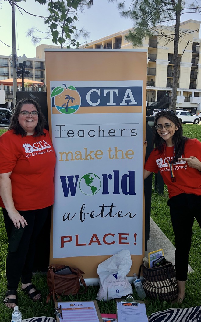 Orange County teachers standing on the outskirts of a rally for LGBTQ and immigrant rights in Orlando, on behalf of their union. - photo by McKenna Schueler