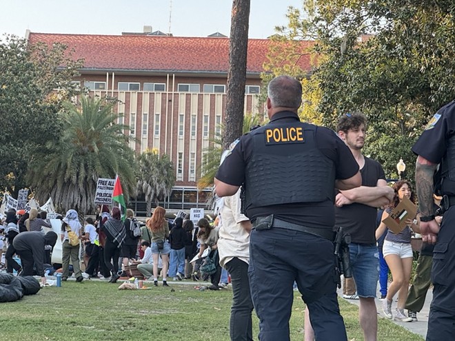 An unidentified University of Florida campus police officer watches over about 50 pro-Palestinian protesters who demonstrated on campus Thursday, April 25, 2024, for a second consecutive day. There was no violence or police response – a contrast to what was happening at some other college campuses around the U.S. - Photo by Amanda Friedman/Fresh Take Florida
