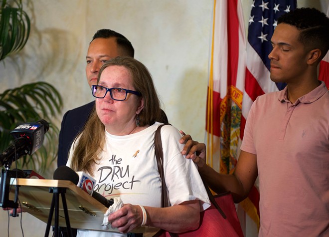 Christine Leinonen, mother of Pulse victim Christopher Leinonen, is comforted by survivor Brandon Wolf. - Photo by Monivette Cordeiro