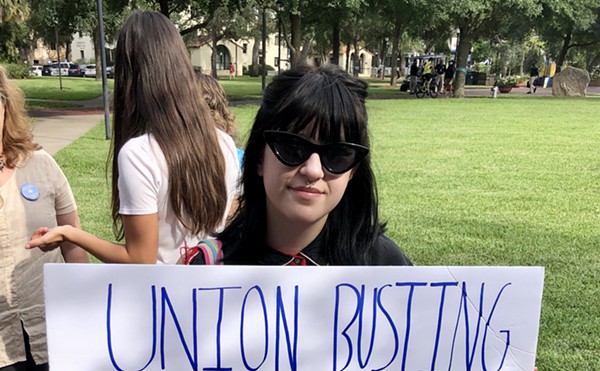 Local college student holds sign reading, "Union busting is disgusting" at a student-organized rally in support of Sodexo workers at Rollins College in Winter Park.