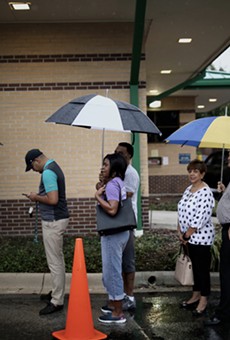Voters stand in the rain in line to vote at the Alafaya Branch Library precinct on Nov. 6 2018, the highest general election day turnout since 2012.