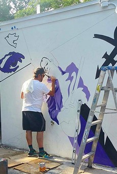 Artist Andrew Spear working on the new Prince mural at Hideaway Bar