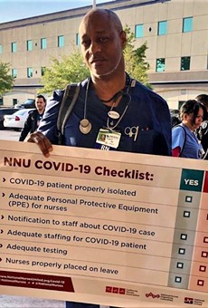 A registered nurse protests outside Osceola Regional Medical Center, holding NNU's signature sign (April 1, 2020).