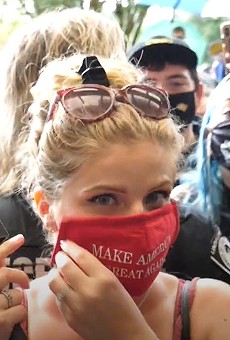 Conservative gun rights activist Kaitlin Bennett puts on her MAGA face covering outside the John C. Hitt library, as per UCF's new COVID-19 policies and UCF PD directives. It took students, staff, and police nearly two hours to get her to comply.