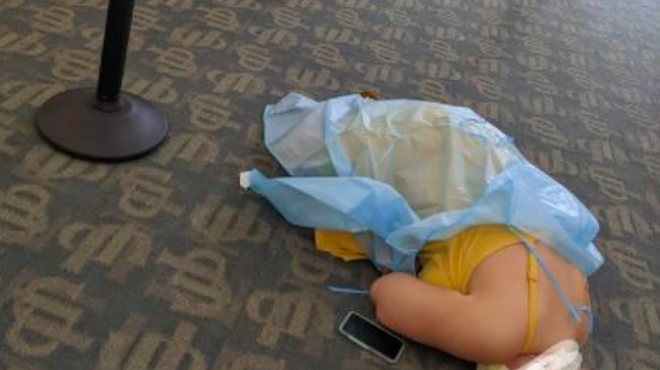 A photo of a woman lying on the floor while waiting for COVID-19 antibody treatment has gone viral.