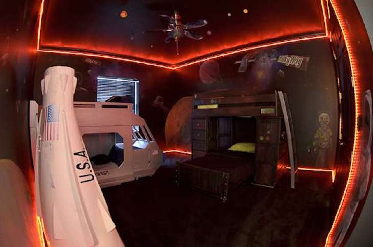  Milky Way Galaxy Bar Bedroom
11207 Gullford Rd, Clermont, 352-250-4220
The Milky Way Galaxy Bar Bedroom is otherworldly with interactive spaceship beds and astronaut appeal.  The entire room is trimmed with neon rope lights keeping the kids safe from aliens craving Milky Way chocolates.  This room also doubles as a lazer tag battle field.
Photo via The Sweet Escape/Website